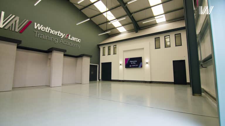 Spacious training academy interior with signage.