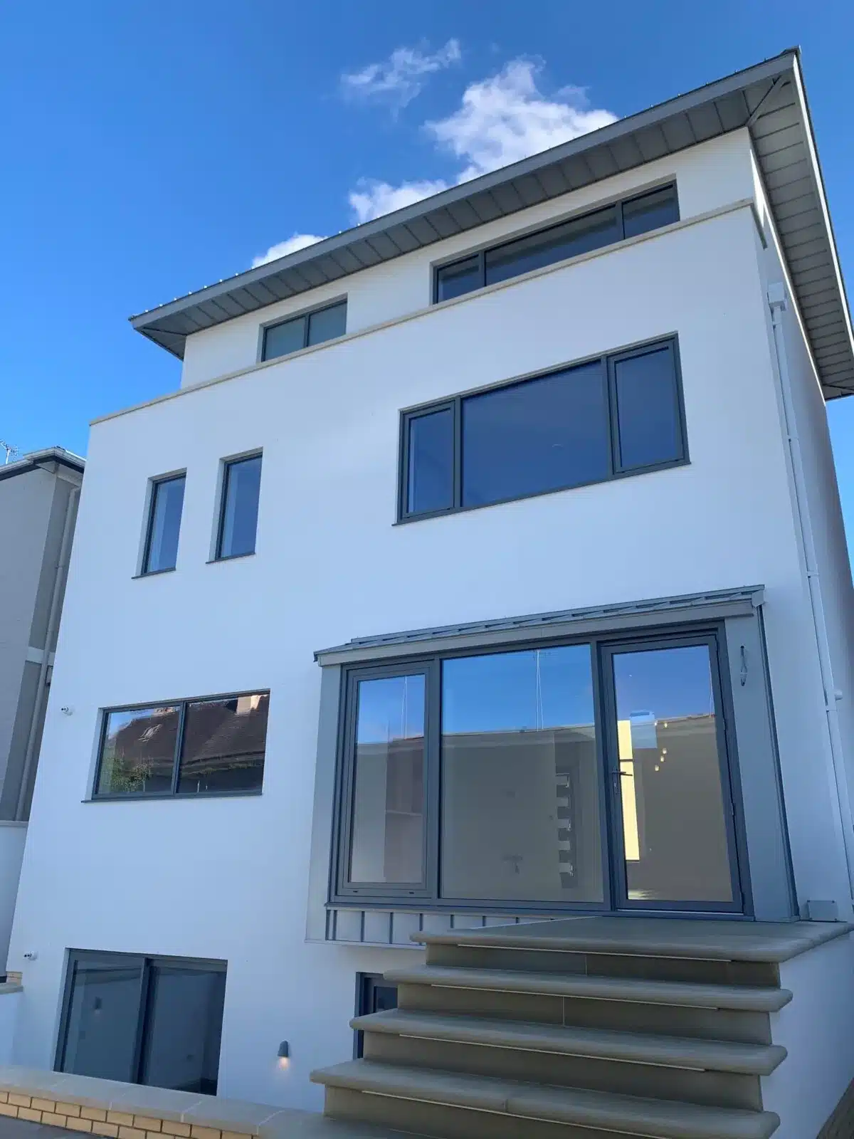 Modern white rendered house with large windows