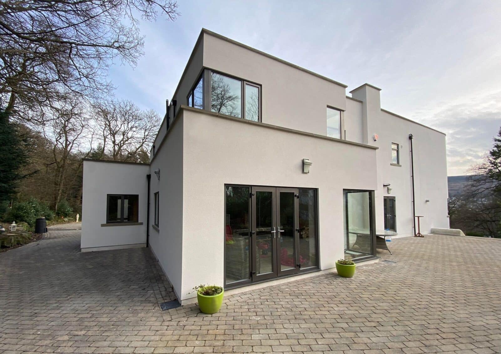 A large, white rendered modern house with large windows.