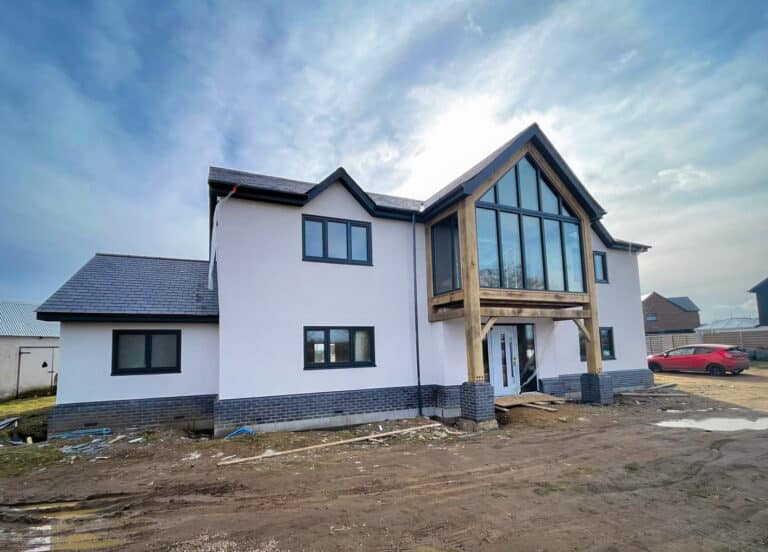 Modern house under construction with large windows and thin coat silicone render