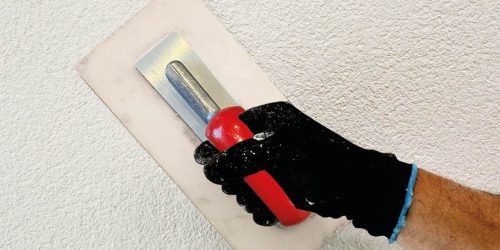 Trowel applying render by hand
