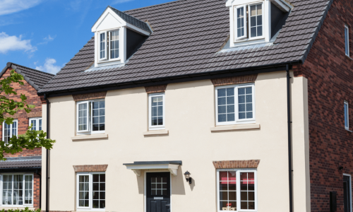 A UK house with cream coloured render and a pitched roof