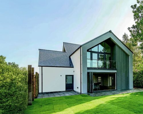 A modern house with external wall insulation (EWI) and green grass outside
