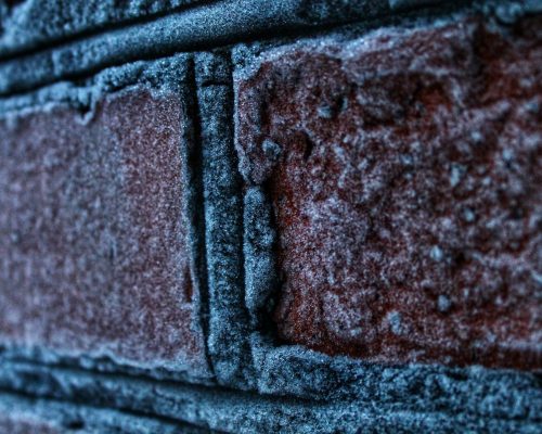 Frost-covered brick wall close-up.